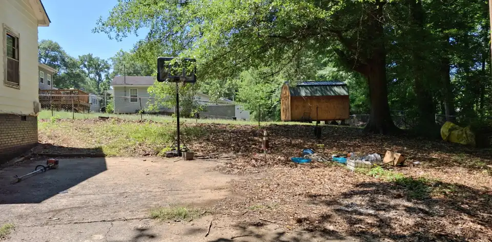 Before: A cluttered back yard slab and lawn cleaned up