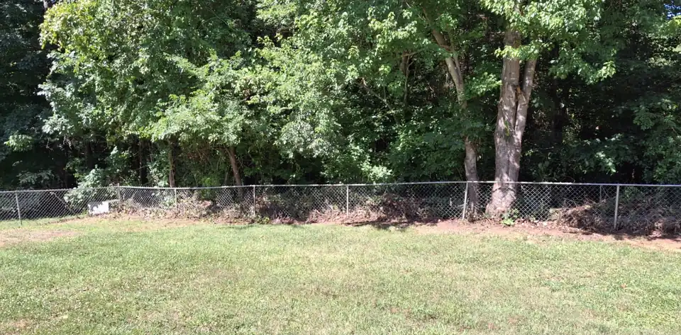 After: An overgrown fence line cleared back to the chain link