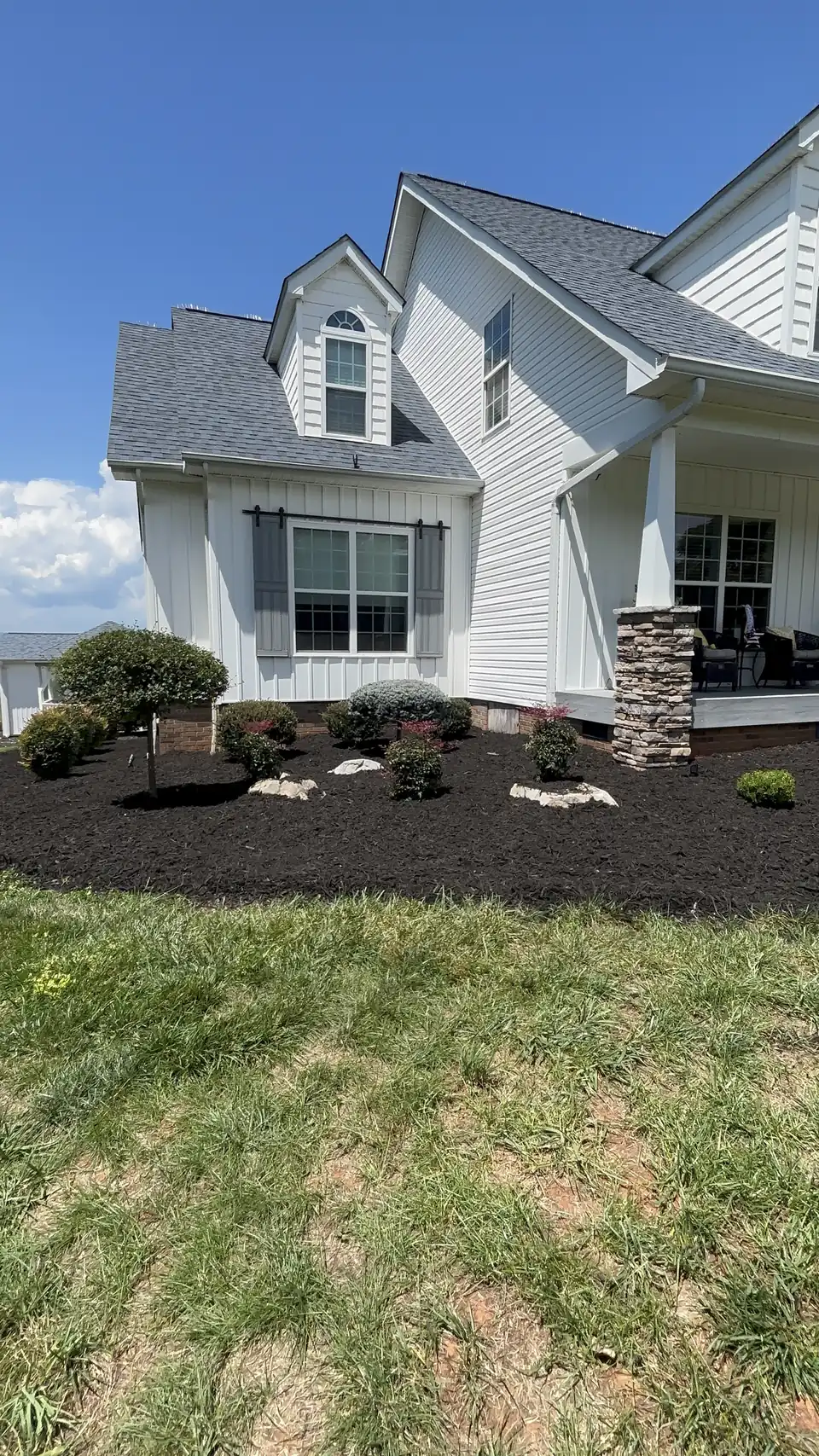 Mulch beds and shrubs at a gabled front porch