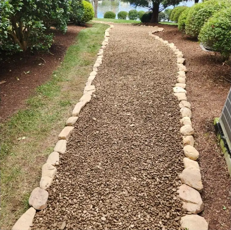 After: A worn grass path turned into a gravel walkway with river rock edging