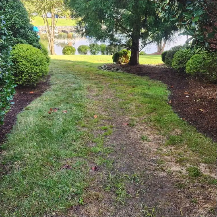 Before: A worn grass path turned into a gravel walkway with river rock edging