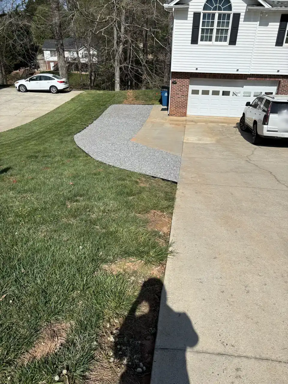 Gravel walkway running beside a concrete driveway