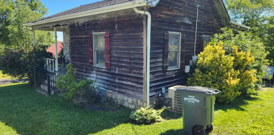 Before: Overgrown shrubs along a cottage replaced with a rock bed and gravel