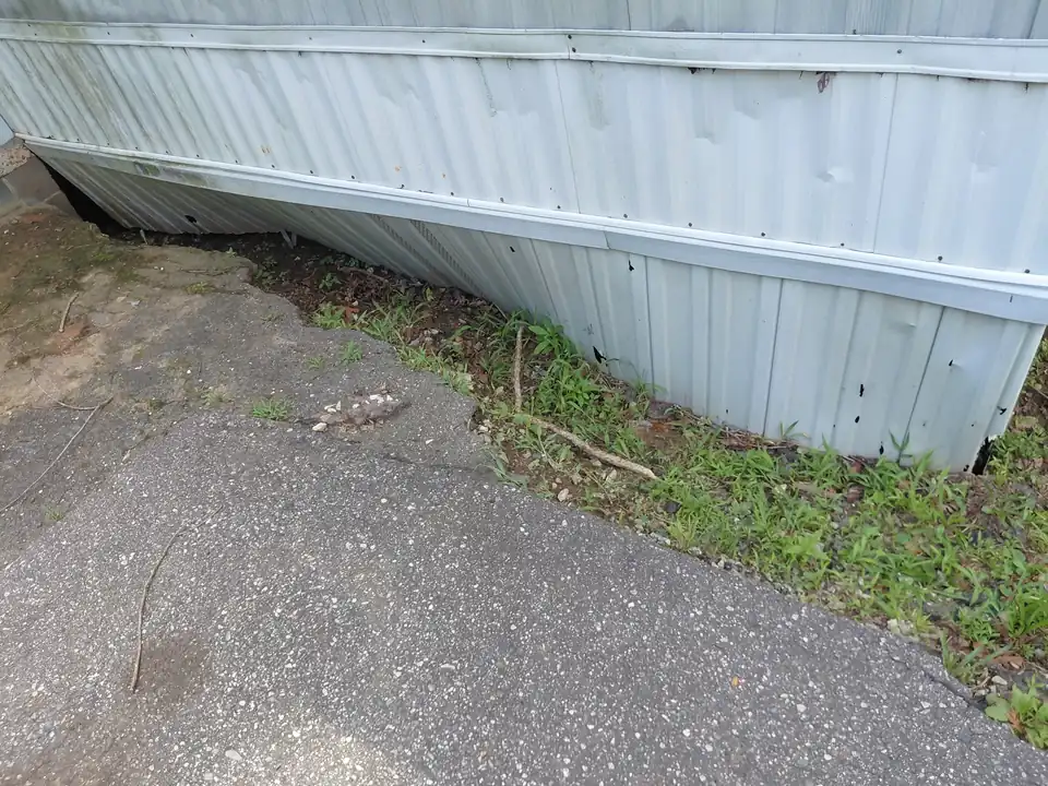 Before: soil washed out under the pavement edge